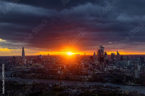 Wide, panoramic view of the 2022 skyline of London during a cloudy sunset with sunflare, England