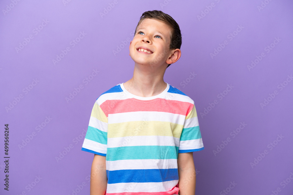 Little boy isolated on purple background thinking an idea while looking up Little boy isolated on purple background thinking an idea while looking up