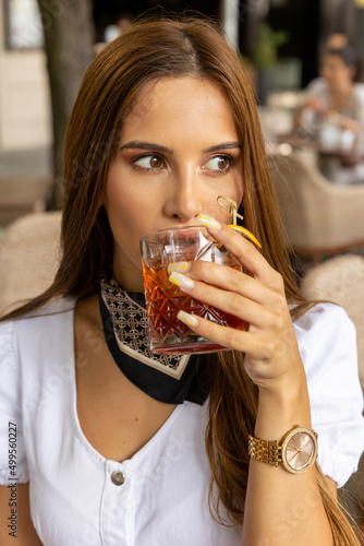 Woman drinking cocktail in the restaurant close up