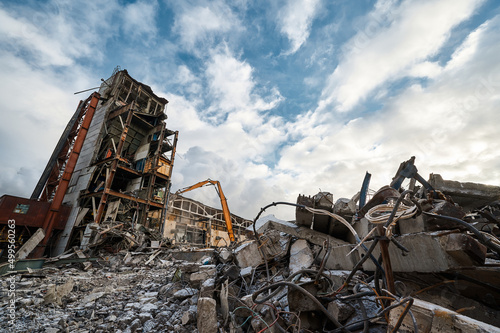 Demolition of old industrial building by huge excavator