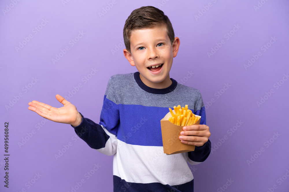 Little boy holding fried chips isolated on purple background with shocked facial expression