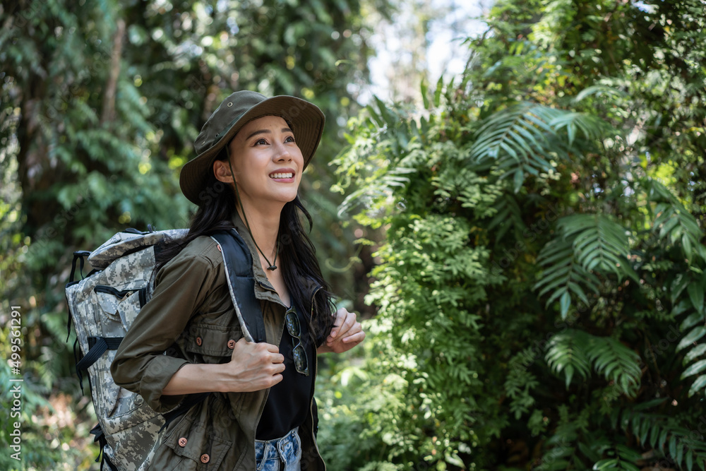 Asian young beautiful female backpacker traveling alone in forest wild