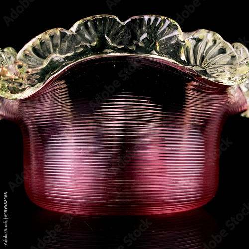 crystal antique figurative vase of pink color. vintage glass red vase in the shape of a flower on a black isolated background