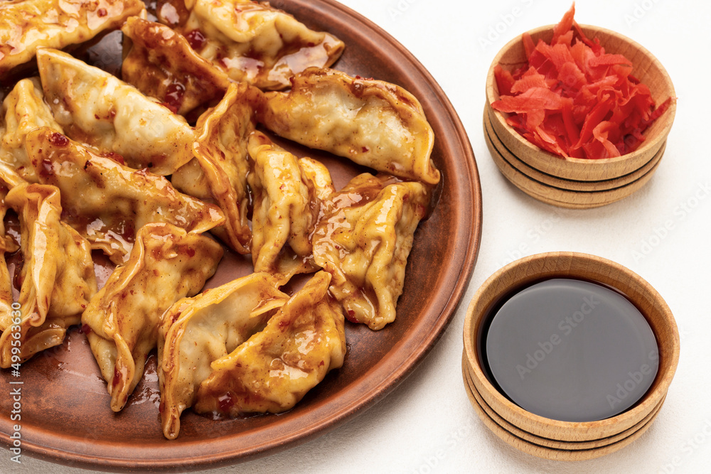 Boiled gedza dumplings in sauce on ceramic plate. Boiled gedza dumplings in sauce on ceramic plate.