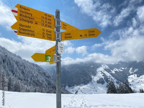 Hiking markings and orientation signs with signposts for navigating in the idyllic winter ambience on the Alpstein mountain massif and in the Swiss Alps - Nesslau, Switzerland / Schweiz © Mario