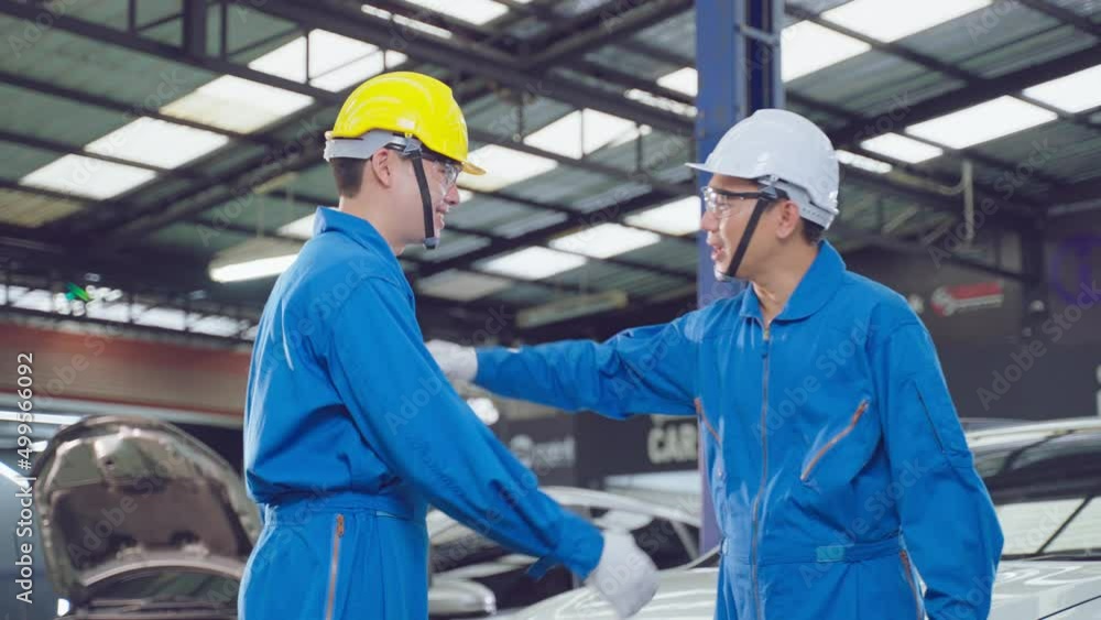 Asian automotive mechanic repairman handshake with engineer in garage. Asian automotive mechanic repairman handshake with engineer in garage.