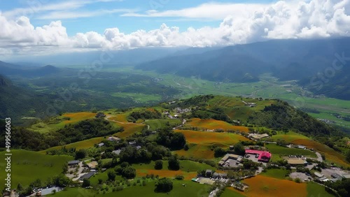 Aerial hyperlapse above Liushidan Mountain, with country roads winding thru daylily flower farms on the hillsides, which overlook the East Rift Valley on a sunny summer day, in Fuli, Hualien, Taiwan photo