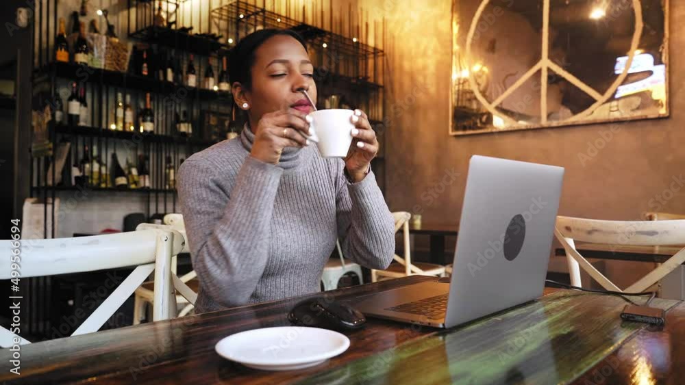 African American Business woman working with laptop at cafe bar ...