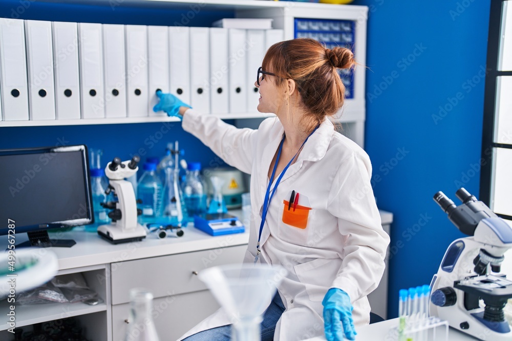Young woman scientist smiling confident holding binder at laboratory Young woman scientist smiling confident holding binder at laboratory