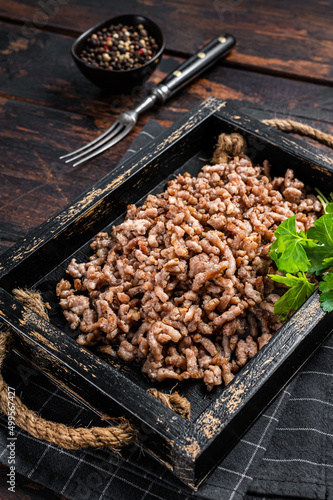 Pan Fried ground beef and lamb meat in a wooden tray with herbs. Wooden background. Top view © Vladimir