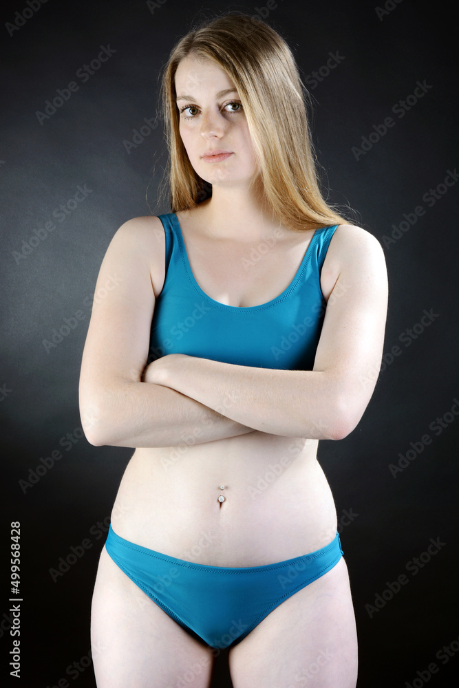 Fototapeta premium Beautiful young woman posing in blue bikini in studio 