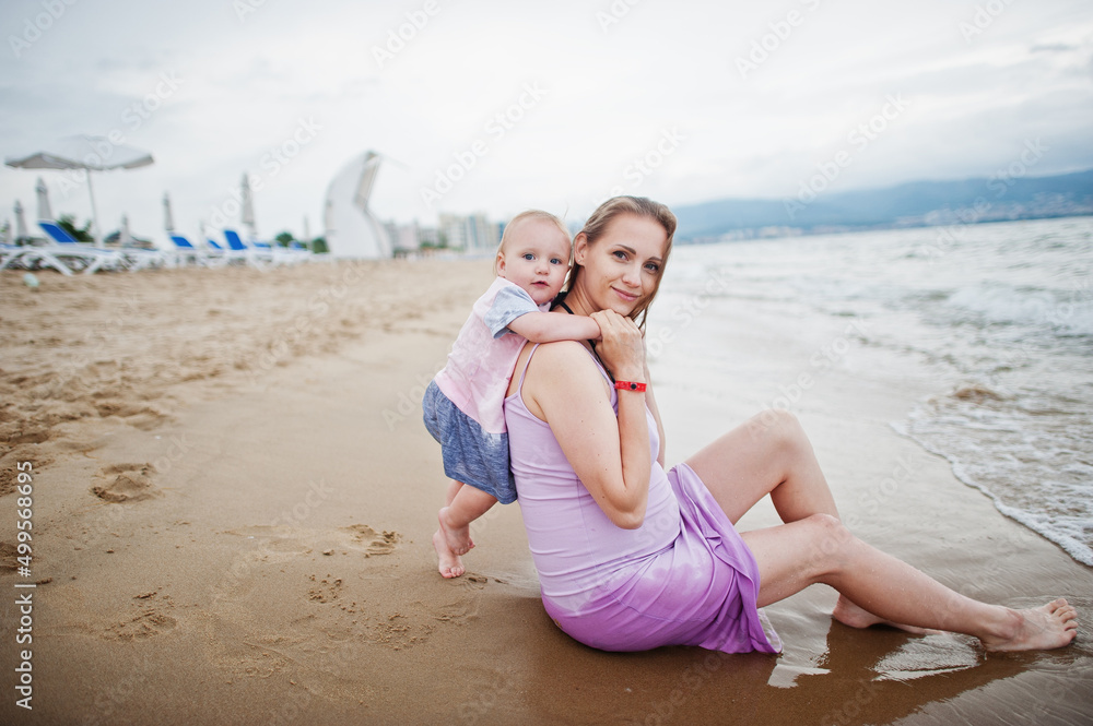 Summer vacations. Parents and people outdoor activity with children. Happy family holidays. Pregnant mother with baby daughter on sea sand beach.