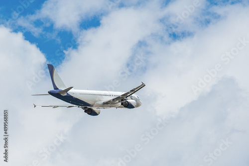 White- blue passenger airplane flying in the sky amazing clouds in the background