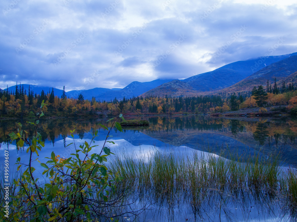 Reflection of mountains and clouds in the calm surface of the lake. Peaceful landscape. Khibiny Reflection of mountains and clouds in the calm surface of the lake. Peaceful landscape. Khibiny