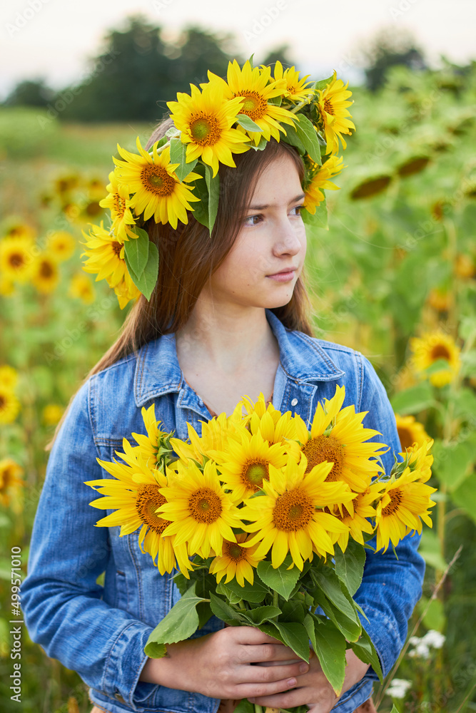 Little beautiful girl in the field
with a wreath of sunflowers on his head with a bouquet in his hands. Little beautiful girl in the field
with a wreath of sunflowers on his head with a bouquet in his hands.
