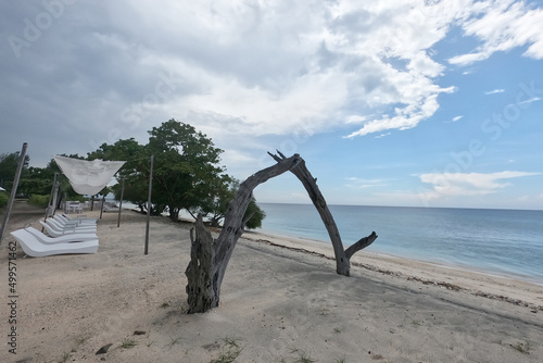 Wooden ornaments and sunbeds under the bright sky sunny day. Beachfront. 