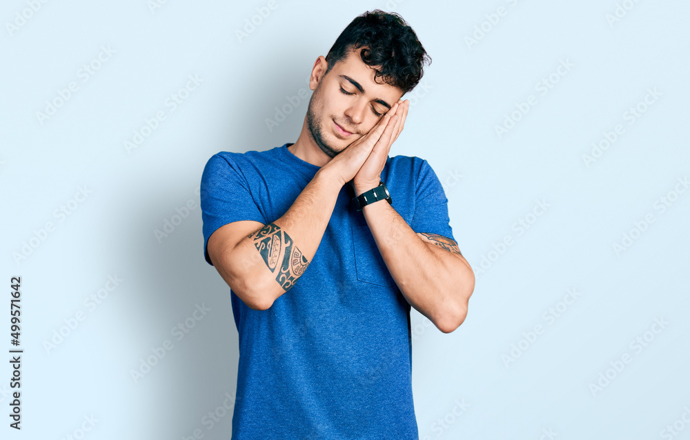 Young hispanic man wearing casual t shirt sleeping tired dreaming and posing with hands together while smiling with closed eyes. Young hispanic man wearing casual t shirt sleeping tired dreaming and posing with hands together while smiling with closed eyes.