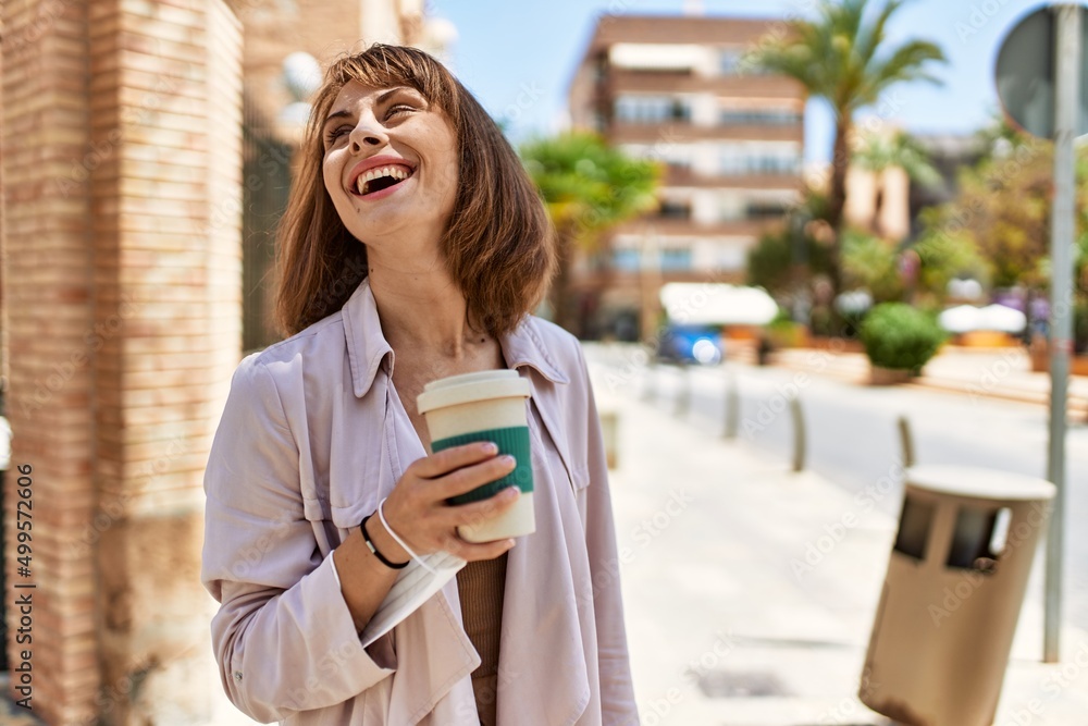 Young caucasian girl smiling happy drinking coffee at the city.