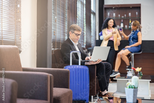 Young businessman looking at laptop screen. Handsome caucasian businessman chatting with clients online, search helpful information on internet while waiting for his flight at airport lounge.