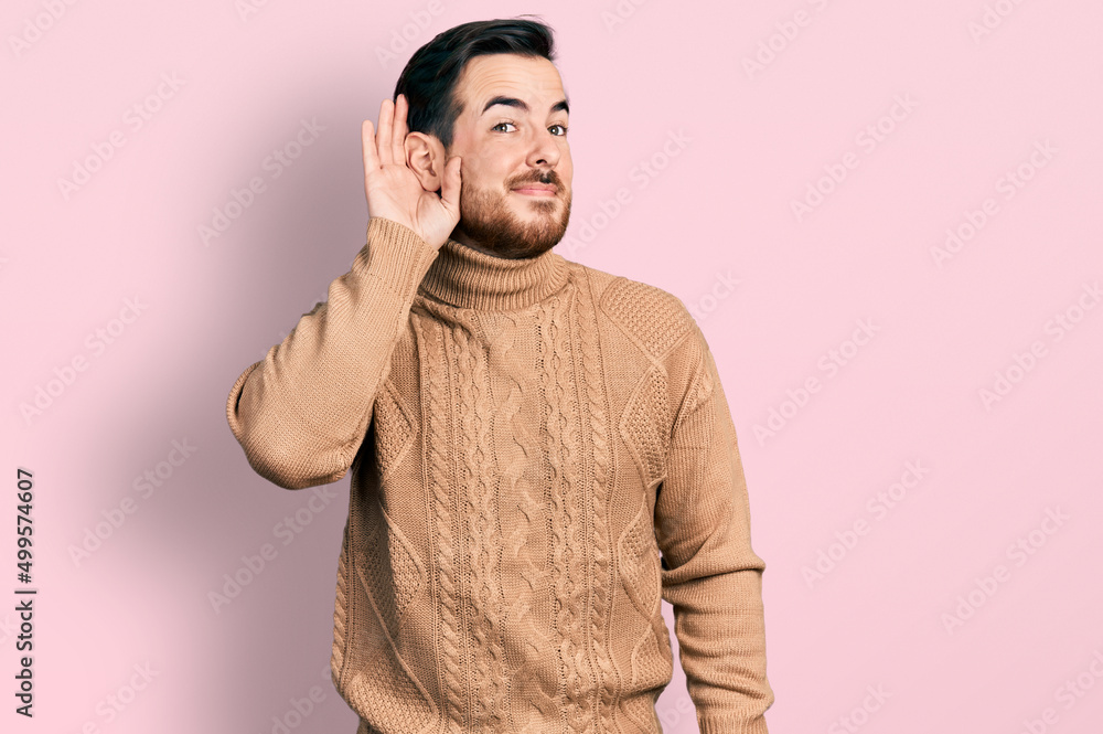 Young hispanic man wearing casual clothes smiling with hand over ear listening an hearing to rumor or gossip. deafness concept. Young hispanic man wearing casual clothes smiling with hand over ear listening an hearing to rumor or gossip. deafness concept.