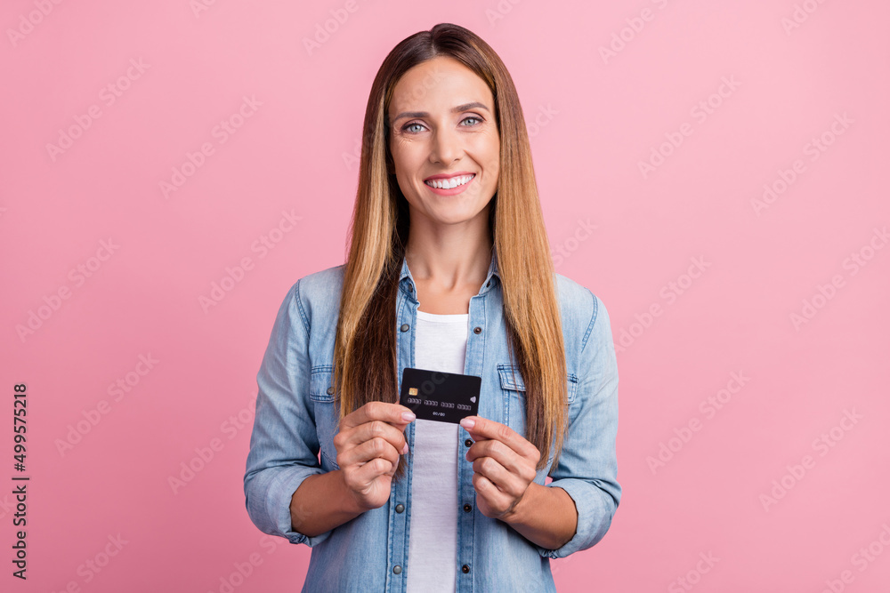 Photo of young cheerful lady promoter hold bank card income profit salary isolated over pink color background Photo of young cheerful lady promoter hold bank card income profit salary isolated over pink color background