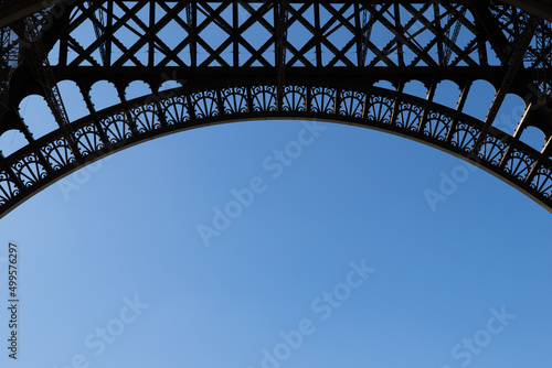 jolie vue sur une partie de la tour Eiffel à Paris en France. Détail de l'architecture de la tour avec un beau ciel bleu en arrière plan et un emplacement libre pour le texte © Tof - Photographie