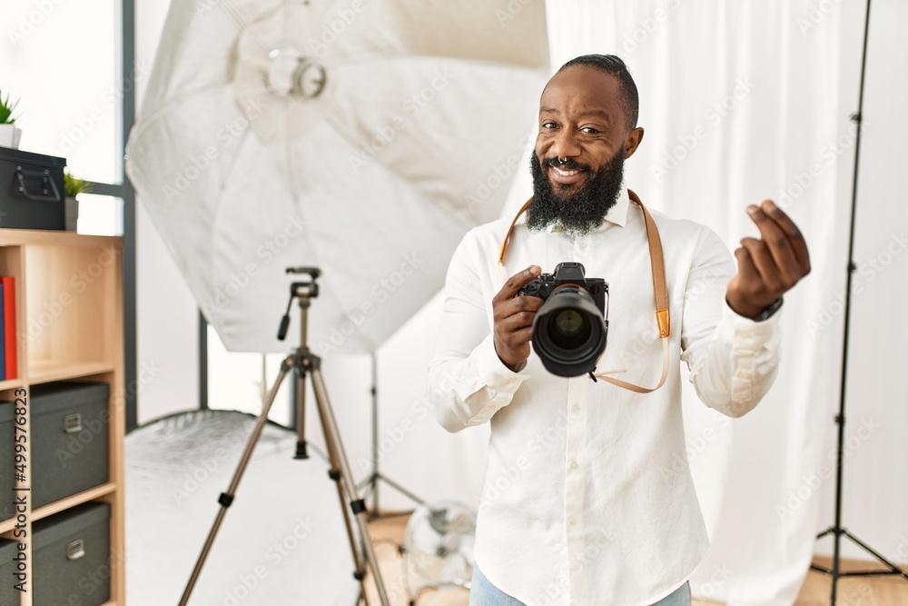 African american photographer man working at photography studio doing