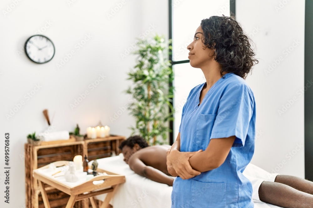 Young therapist woman at wellness spa center looking to side, relax profile pose with natural face with confident smile. Young therapist woman at wellness spa center looking to side, relax profile pose with natural face with confident smile.