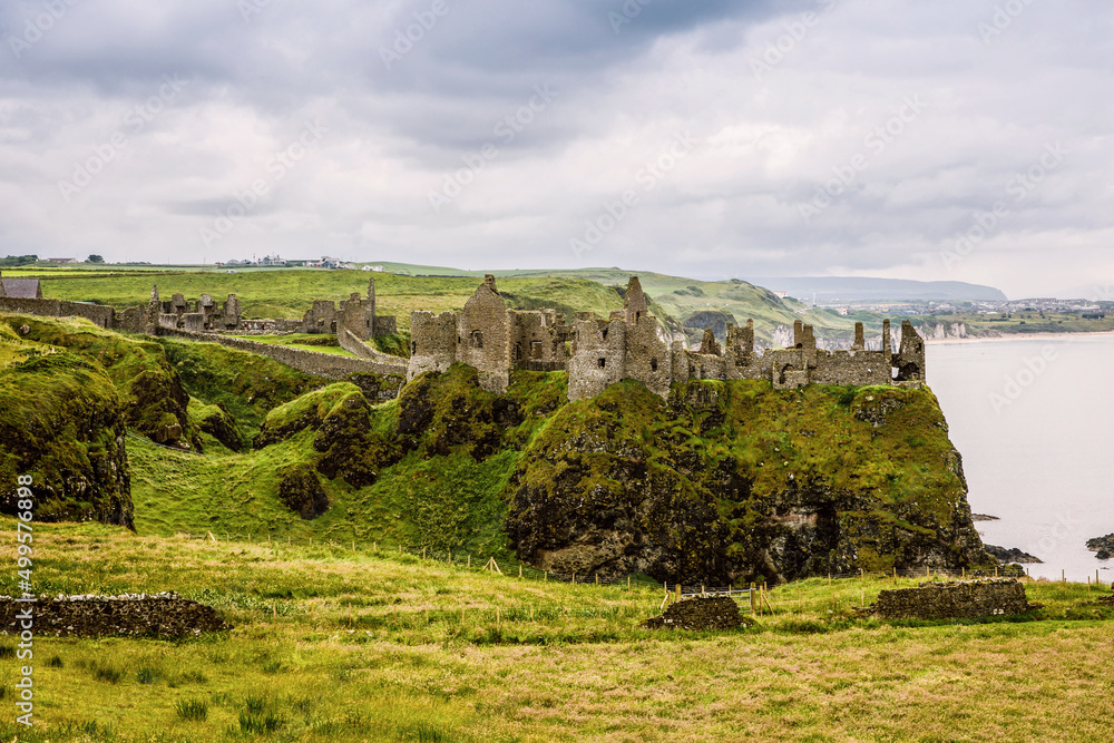 Ruins of Dunluce Castle, Antrim, Northern Ireland during sunny day with semi cloudy sky. Irish ancient castle near Wild Atlantic Way.