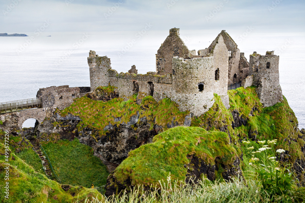 Ruins of Dunluce Castle, Antrim, Northern Ireland during sunny day with semi cloudy sky. Irish ancient castle near Wild Atlantic Way. Ruins of Dunluce Castle, Antrim, Northern Ireland during sunny day with semi cloudy sky. Irish ancient castle near Wild Atlantic Way.