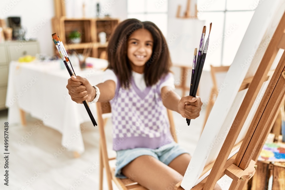 African american girl smiling confident holding paintbrushes at art school African american girl smiling confident holding paintbrushes at art school