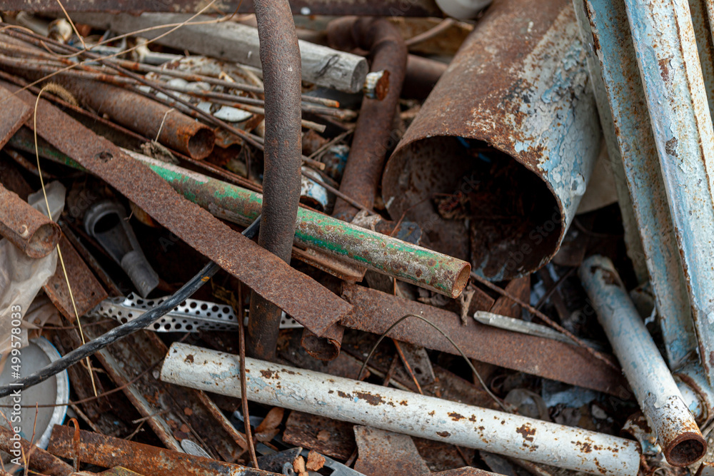 scrap metal, old rusty metal lying on green grass. Pipes, batteries, heating system is old outside scrap metal, old rusty metal lying on green grass. Pipes, batteries, heating system is old outside