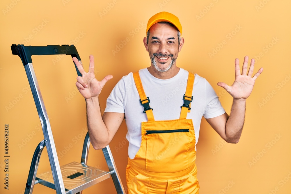 Handsome middle age man with grey hair holding ladder showing and pointing up with fingers number eight while smiling confident and happy. Handsome middle age man with grey hair holding ladder showing and pointing up with fingers number eight while smiling confident and happy.