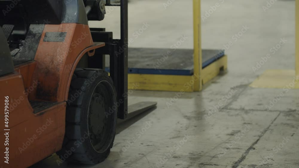 Forklift parked in front of industrial scale, waiting to do warehouse work. Cinematic details. Forklift parked in front of industrial scale, waiting to do warehouse work. Cinematic details.