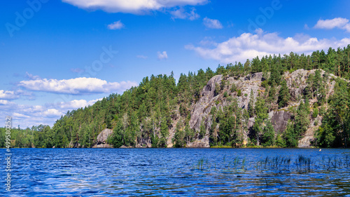 Landscape of the forest lake Yastrebinoye with ice age rocks in the background. photo