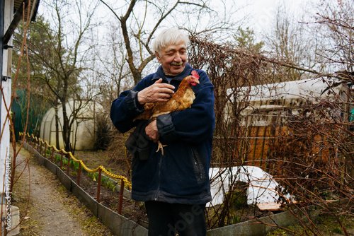 Wallpaper Mural A farmer holds a chicken in his arms in the village strokes it and smiles Torontodigital.ca