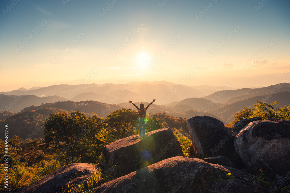 Silhouette young hiker woman standing on top of mountain peak in the ...