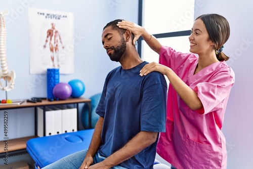 Man and woman wearing physiotherapist uniform having rehab session stretching neck at physiotherpy clinic