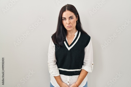 Young hispanic woman standing over isolated background depressed and worry for distress, crying angry and afraid. sad expression.