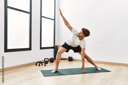Young arab man smiling confident training yoga at sport center