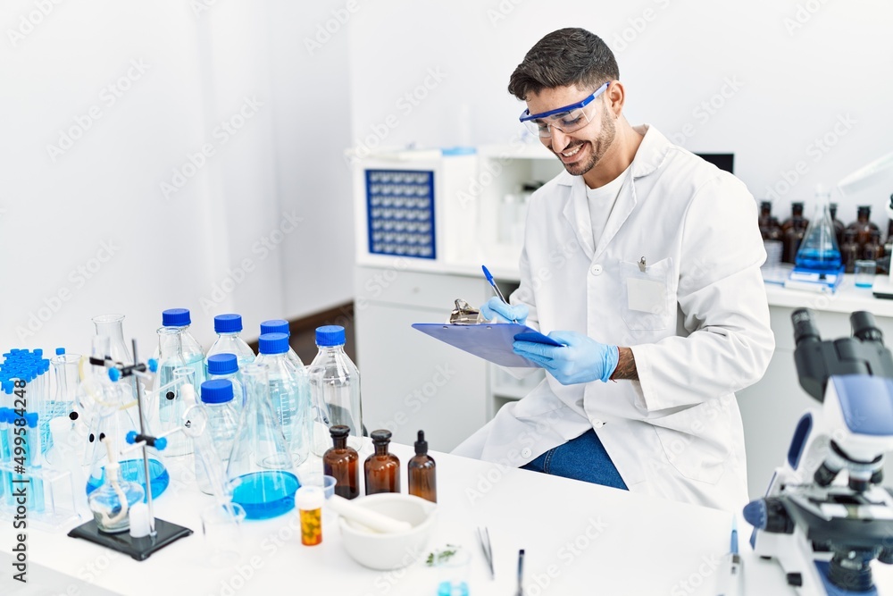 Fototapeta premium Handsome hispanic man working as scientific at laboratory