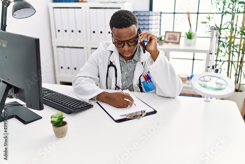 Young african man working as doctor speaking on the phone at medical clinic