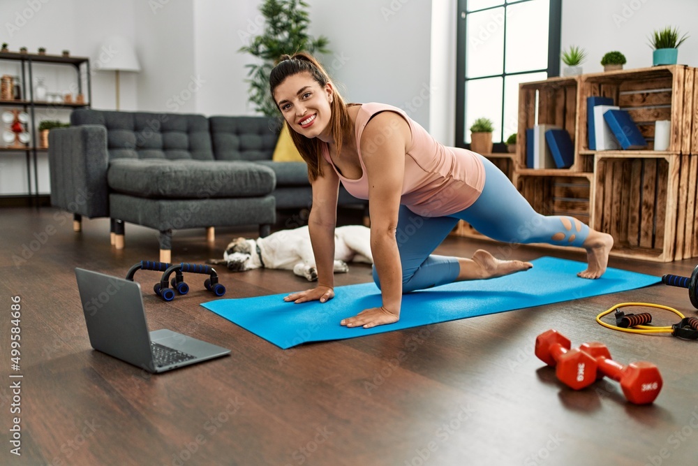 Young woman smiling confident having online abs exercise class at home Young woman smiling confident having online abs exercise class at home