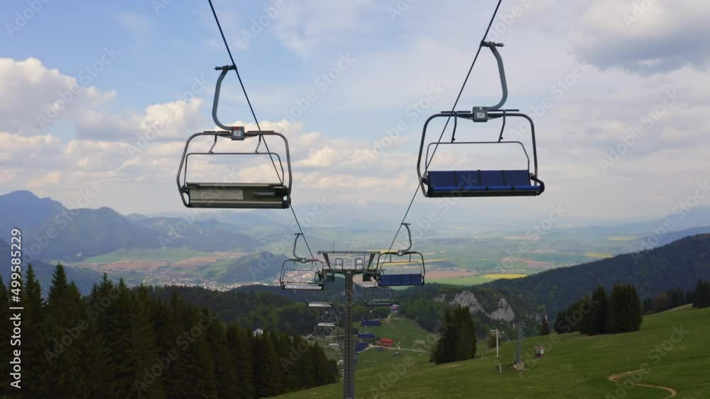 Malino Brdo Resort, Ružomberok, Liptov, Slovakia - Empty Ski Chairlift Cable Over Lush Green Hills And Meadows In Summer. - Drone Pullback Shot Malino Brdo Resort, Ružomberok, Liptov, Slovakia - Empty Ski Chairlift Cable Over Lush Green Hills And Meadows In Summer. - Drone Pullback Shot