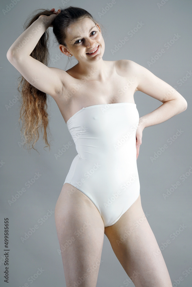 Cheerful happy woman posing in white one piece swimsuit in studio Stock Photo Adobe Stock