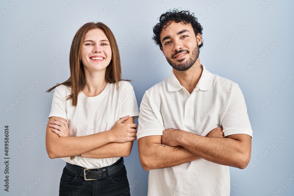 Young couple wearing casual clothes standing together happy face smiling with crossed arms looking at the camera. positive person. Young couple wearing casual clothes standing together happy face smiling with crossed arms looking at the camera. positive person.