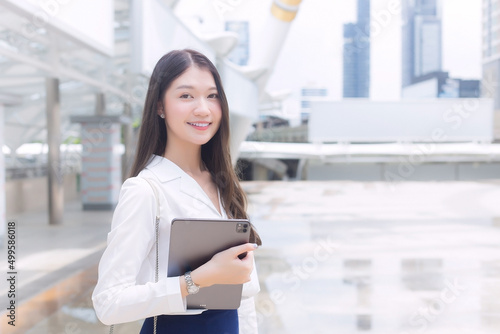 Young Asian Business woman is going to the office or workplace which she holds notepad in her hands in business background theme. Free Download Young Asian Business woman is going to the office or workplace which she holds notepad in her hands in business background theme. - GFXLoad