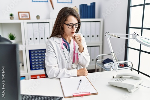 Young doctor woman wearing doctor uniform and stethoscope at the clinic feeling unwell and coughing as symptom for cold or bronchitis. health care concept.