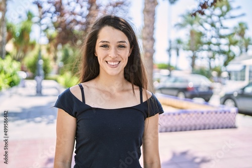 Young hispanic girl smiling happy standing at the city.