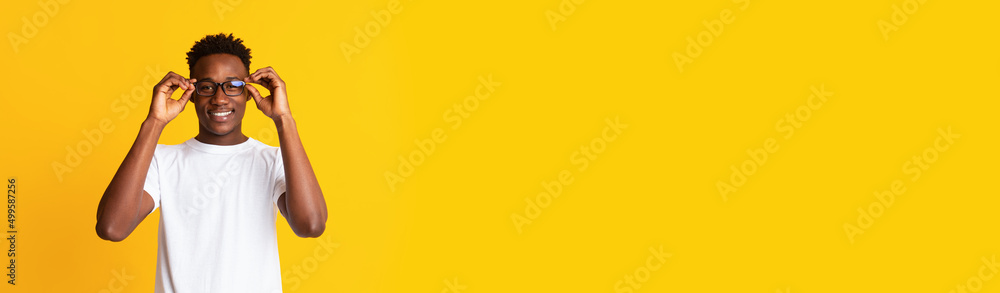 Naklejka premium Long shot with handsome black guy in stylish eyeglasses over yellow background